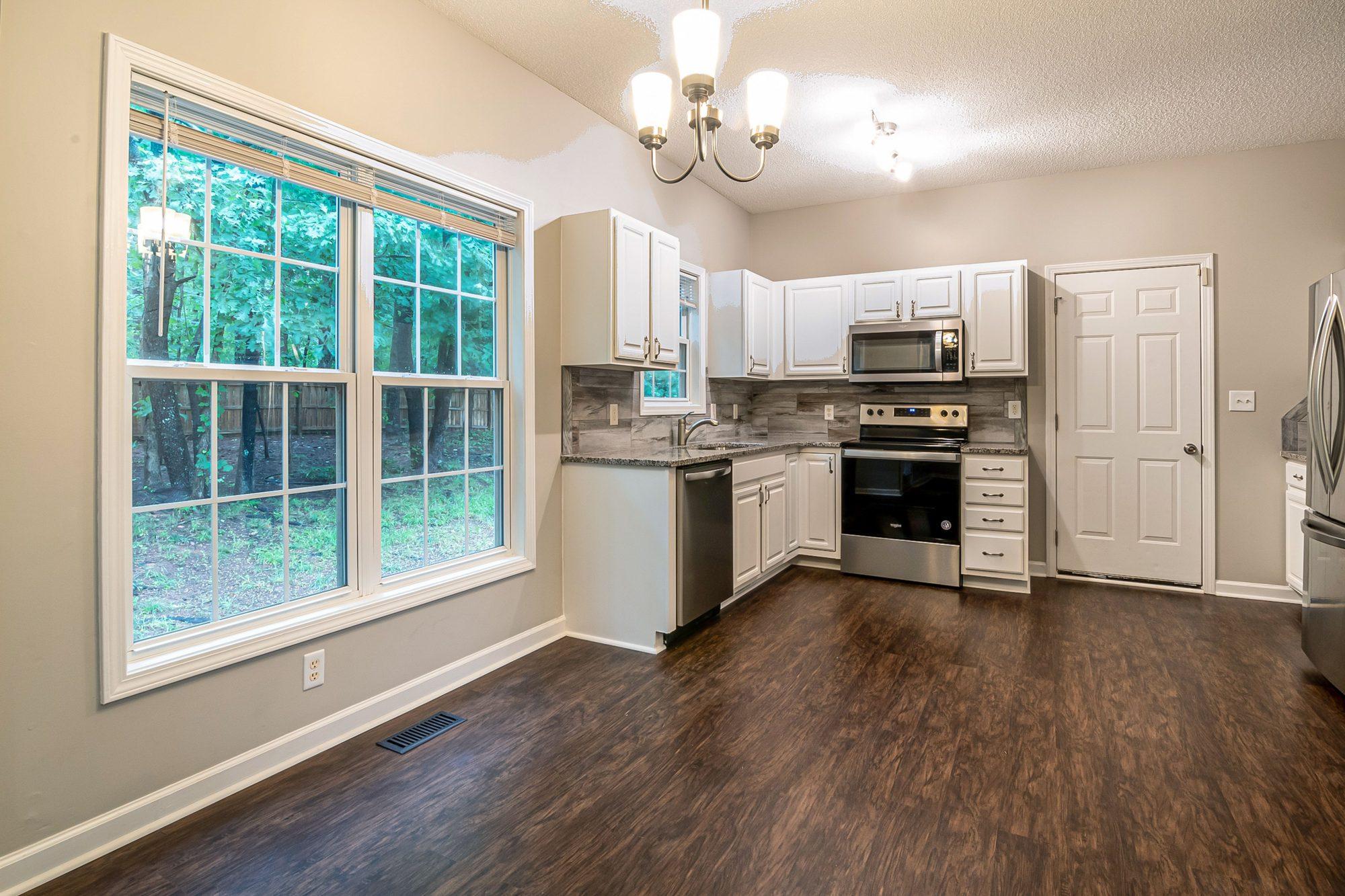 Freshly renovated rental kitchen with white cabinets and stainless appliances